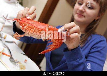 La ragazza tiene aragosta di cucina nel ristorante Foto Stock