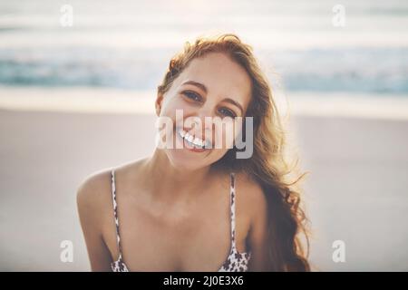 Im a casa vicino al mare. Scatto corto di una giovane donna che si gode la sua giornata in spiaggia. Foto Stock