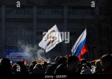 Mosca, Russia. 18th Mar 2022. 18 marzo 2022, Russia, Moskau: La gente ha bandiere ai margini di un concerto per celebrare l'ottavo anniversario dell'annessione della penisola del Mar Nero di Crimea il 18 marzo 2014. Credit: dpa Picture Alliance/Alamy Live News Foto Stock