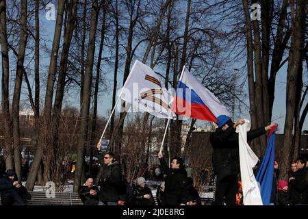 Mosca, Russia. 18th Mar 2022. 18 marzo 2022, Russia, Moskau: La gente ha bandiere ai margini di un concerto per celebrare l'ottavo anniversario dell'annessione della penisola del Mar Nero di Crimea il 18 marzo 2014. Credit: dpa Picture Alliance/Alamy Live News Foto Stock