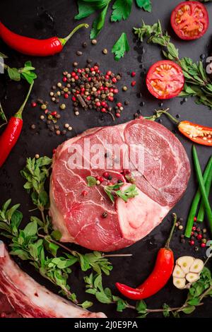 Materie Stinco di vitello su sfondo scuro pronto per la tostatura Foto Stock