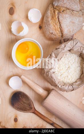 La cottura Ingredienti - uovo, guscio d'uovo, la farina, il matterello, cucchiaio Foto Stock