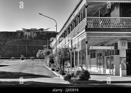Strade a contrasto bianco-nero ed edifici storici della collina rotta australiana Outback città mineraria verso la linea di Lode Memorial. Foto Stock