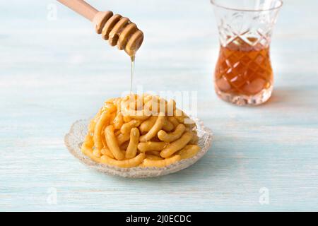 Chak Chak, pezzi di pasta in miele, dessert tradizionale tatar su sfondo azzurro chiaro Foto Stock