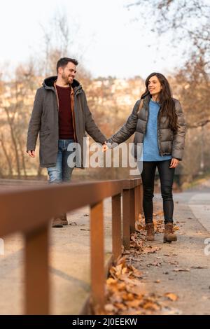 Giovane coppia eterosessuale che cammina in un parco e parla Foto Stock