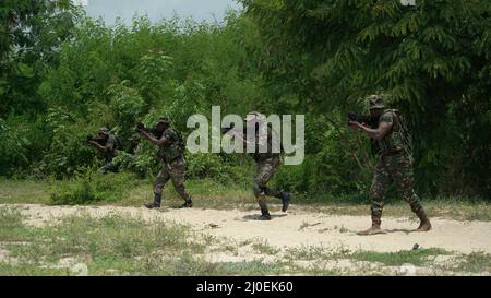 Tanzania People’s Defense Force (TPDF), soldati delle forze speciali marine (MSF) praticano tattiche di piccole unità con l'esercito americano Green Beret assegnato a 3rd Special Forces Group durante un Joint Combined Exchange Training (JCET) a Dar es Salaam, Tanzania, 3 marzo 2022. Le squadre si sono concentrate sull'affinare le abilità di base come la cura di base, le tattiche di piccola unità e la pianificazione della missione. (Foto di U.S. Air Force staff Sgt. Andrew Fox) Foto Stock