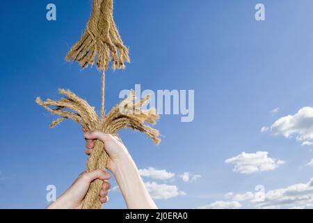 Un uomo che tiene su una corda sfrangiante Foto Stock