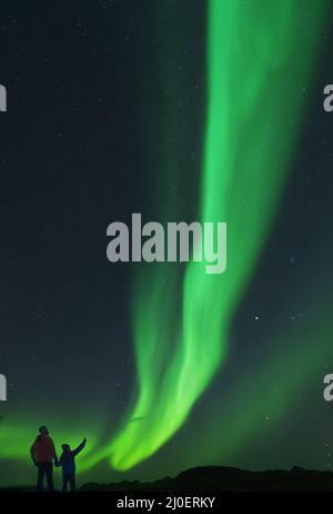 Padre e figlia ammirando le luci del nord Foto Stock