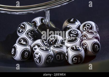 Palline di lotteria bianche e nere in una macchina Foto Stock