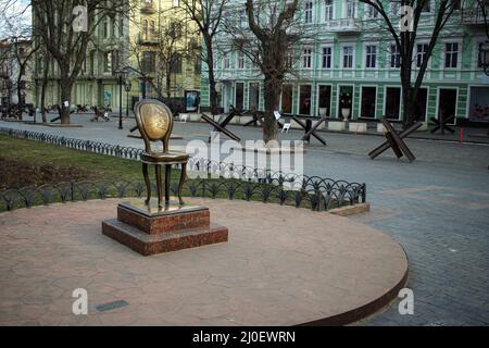 Odessa, Ucraina. 18th Mar 2022. Il Monumento a Ilf e Petrov '12th sedia' visto su Deribasovskaya strada, nel suo sfondo sono diversi hedgehog anti-serbatoio. Strade di Odessa, Ucraina durante la guerra russo-ucraina. Credit: SOPA Images Limited/Alamy Live News Foto Stock