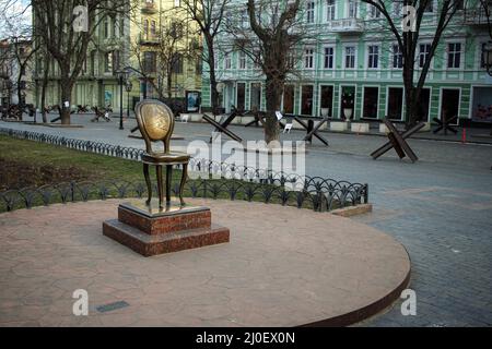 Odessa, Ucraina. 18th Mar 2022. Il Monumento a Ilf e Petrov '12th sedia' visto su Deribasovskaya strada, nel suo sfondo sono diversi hedgehog anti-serbatoio. Strade di Odessa, Ucraina durante la guerra russo-ucraina. (Foto di Viacheslav Onyshchenko/SOPA Images/Sipa USA) Credit: Sipa USA/Alamy Live News Foto Stock