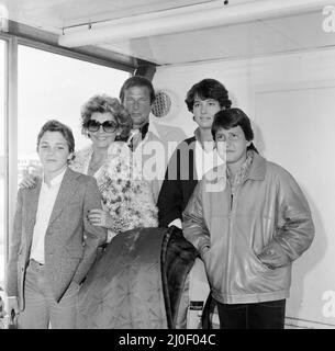 Roger Moore con la moglie Luisa e la famiglia, figlia Deborah (16), figlio Geoffrey (14) e Sacha Newley (14, a sinistra della foto). Sono tutti arrivati da Nizza dove sono stati in vacanza. Roger è qui per promuovere il suo ultimo film "North Sea Hijack". 8th aprile 1980. Foto Stock