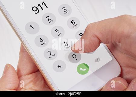 Chiamata di emergenza tenendo le mani un telefono Foto Stock