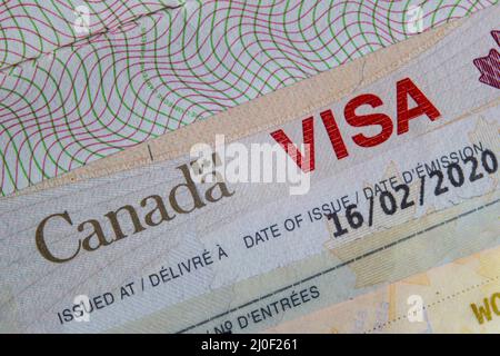 Un primo piano di UN VISTO del Canada su un passaporto all'interno della pagina Foto Stock