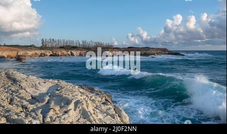 Onde di mare che si infrangono sulle rocce di una spiaggia rocciosa, Peyia, Paphos, Cipro Foto Stock