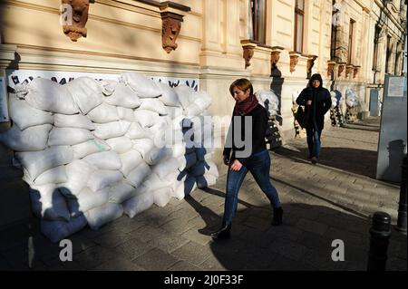 Lviv, Ucraina. 18th Mar 2022. La gente cammina davanti a sacchi di sabbia all'esterno di un edificio in mezzo all'invasione russa a Lviv. Le truppe russe sono entrate in Ucraina il 24 febbraio. (Foto di Mykola TYS/SOPA Images/Sipa USA) Credit: Sipa USA/Alamy Live News Foto Stock