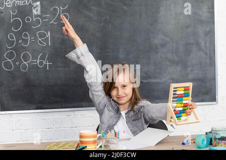 Lo studente riferisce di rispondere in classe per rispondere alla domanda dell'insegnante. Foto Stock