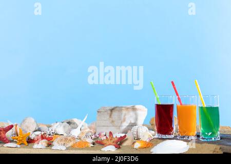 Succo di frutta fresca di arancia, affidabile, fragole si trova su un asse di legno proprio sulla spiaggia di sabbia. Foto Stock