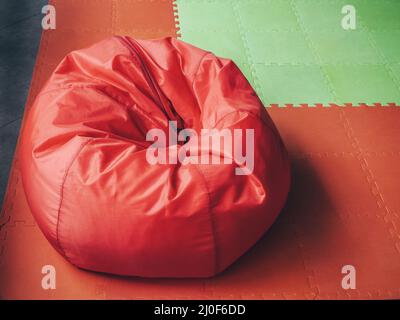 Borsa rotonda rossa morbida sul pavimento verde rosso Foto Stock