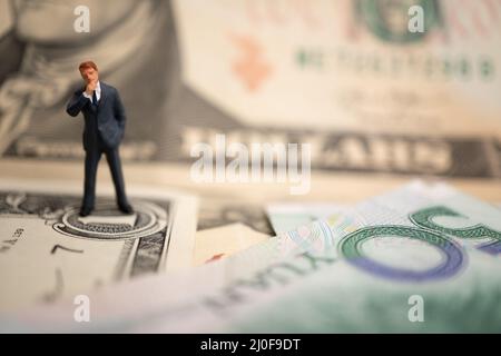 La figura imprenditore in piedi sul dollaro e yuan banconota, tenendo le mani per il successo in accordi commerciali. Concetto di guerra di trading Foto Stock