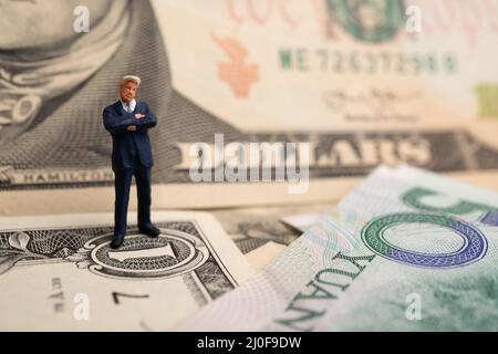 La figura imprenditore in piedi sul dollaro e yuan banconota, tenendo le mani per il successo in accordi commerciali. Concetto di guerra di trading Foto Stock
