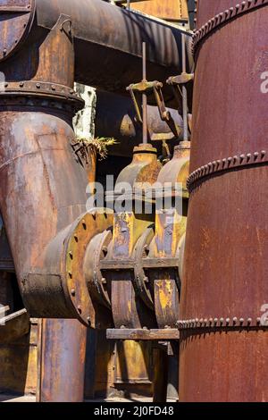 Ingranaggi e tubazioni corrosi e arrugginiti provenienti da macchinari vecchi Foto Stock