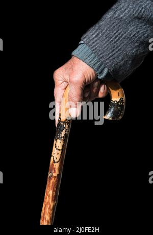Uomo anziano che tiene un bastone da passeggio di legno Foto Stock