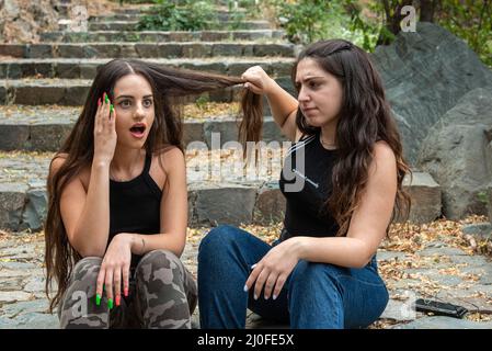 Due donne combattimenti e tirando ogni altri capelli Foto Stock