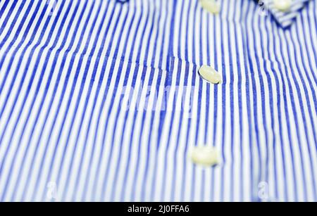 Il bottone di una camicia a righe blu con un colletto con un bottone rivolto verso il basso Foto Stock