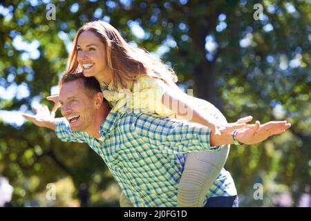 Giocoso nel sole estivo. Scatto di una coppia giocosa godendo il sole d'estate. Foto Stock