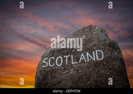 Il cartello di confine scozzese al tramonto Foto Stock