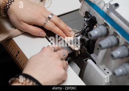 Un primo piano di come un giovane comò cucini una tracolla di abito. Foto Stock