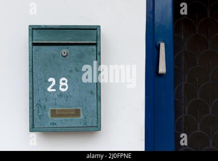 Casella lettera in metallo verde su una parete bianca Foto Stock