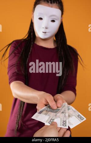 Una mano maschio raggiunge per le fatture di carta date da una giovane donna anonima. Figura isolata di colore arancione. Foto Stock