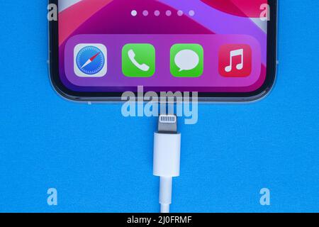 Calgary, Alberta, Canada. 19 novembre 2020. Un iPhone Pro con un cavo Lightning-USB su sfondo blu. Foto Stock