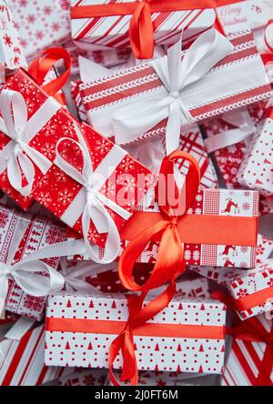 Una pila di varie dimensioni avvolta in regali di carta natalizia messi in pila. Concetto di Natale Foto Stock