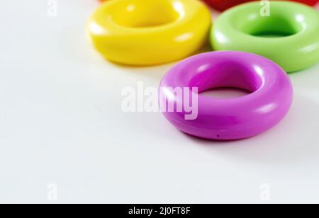 Anelli colorati in plastica isolati su sfondo bianco. Foto Stock