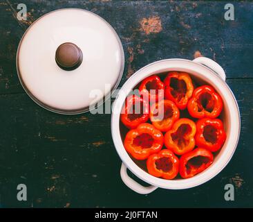 Peperoni rossi sbucciati da semi preparati per il ripieno in una pentola, vista ravvicinata dall'alto Foto Stock