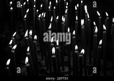 Candele di cera bruciante nel tempio foto in bianco e nero Foto Stock