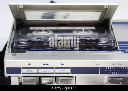 Dettaglio della testa dietro il nastro magnetico di una vecchia cassetta audio inserita in un lettore Foto Stock