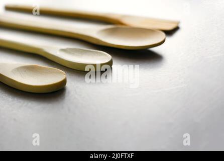 Gruppo di cucchiai da cucina in legno disposti su un marmo grigio tabella Foto Stock