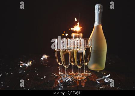 La composizione party immagine. Bicchieri riempiti con champagne posto sulla tavola nera Foto Stock