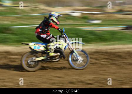 Atleta non riconosciuto che guida una moto sportiva su una gara di motocross Foto Stock