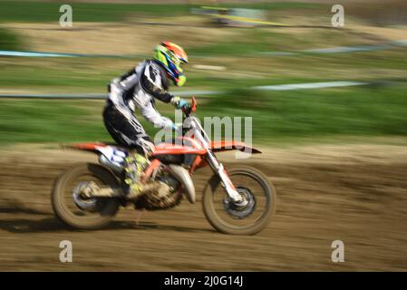 Atleta non riconosciuto che guida una moto sportiva su una gara di motocross Foto Stock