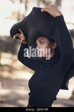 Un cappello femminile dovrebbe parlare dei volumi. Scatto di una giovane donna alla moda che si posa su uno sfondo naturale. Foto Stock