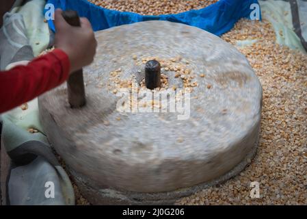 Rettificatrice a pietra rotante a mano umana per frantumare i grani. Tritatutto manuale per attrezzature artigianali Foto Stock