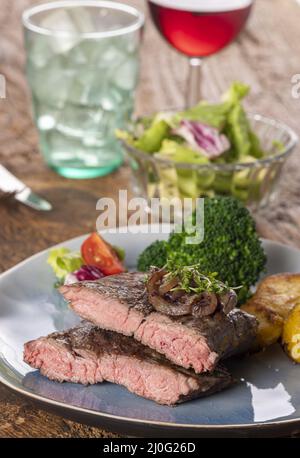 Metà di una bistecca sul piatto Foto Stock