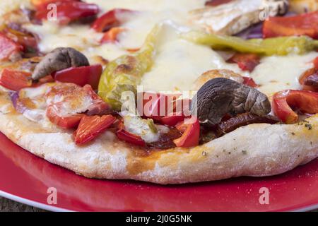 Primo piano di una pizza su un piatto Foto Stock