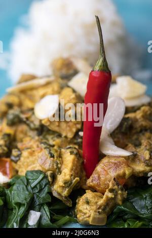 Curry indiano Murgh Palak su un piatto blu Foto Stock