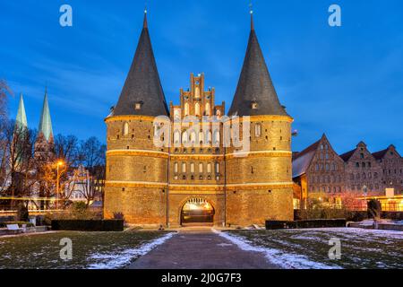 L'iconica porta di Holsten a Lubecca, in Germania, di notte Foto Stock